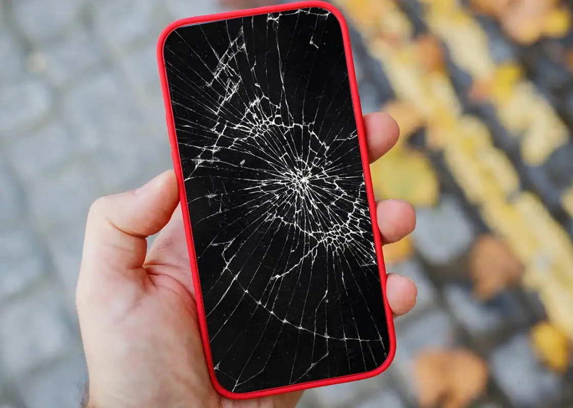 Cracked phone screen in hand